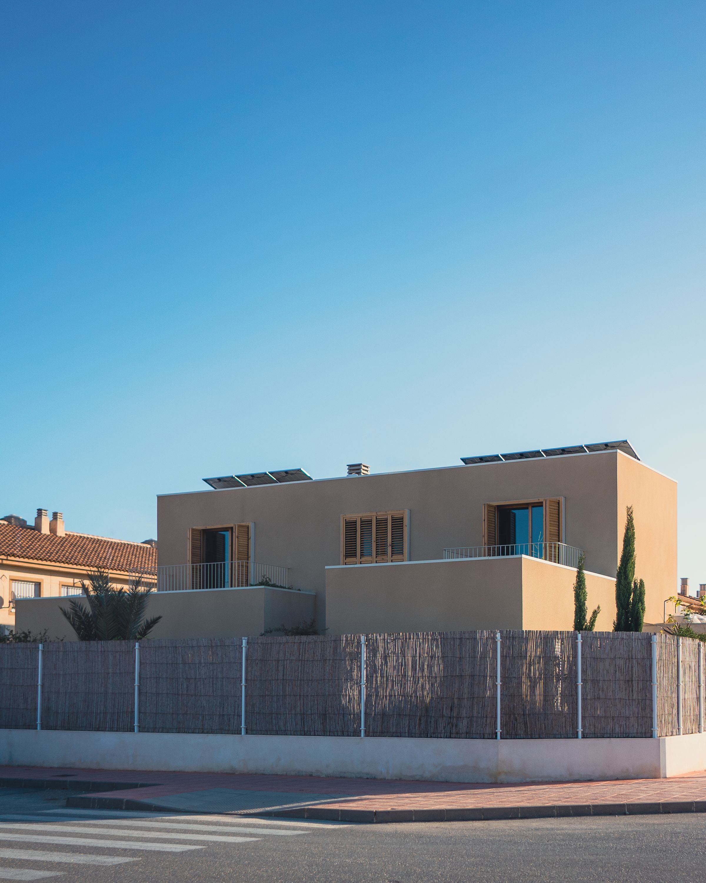 Maison individuelle à toit plat avec des modules photovoltaïques posés sur le toit, ciel bleu