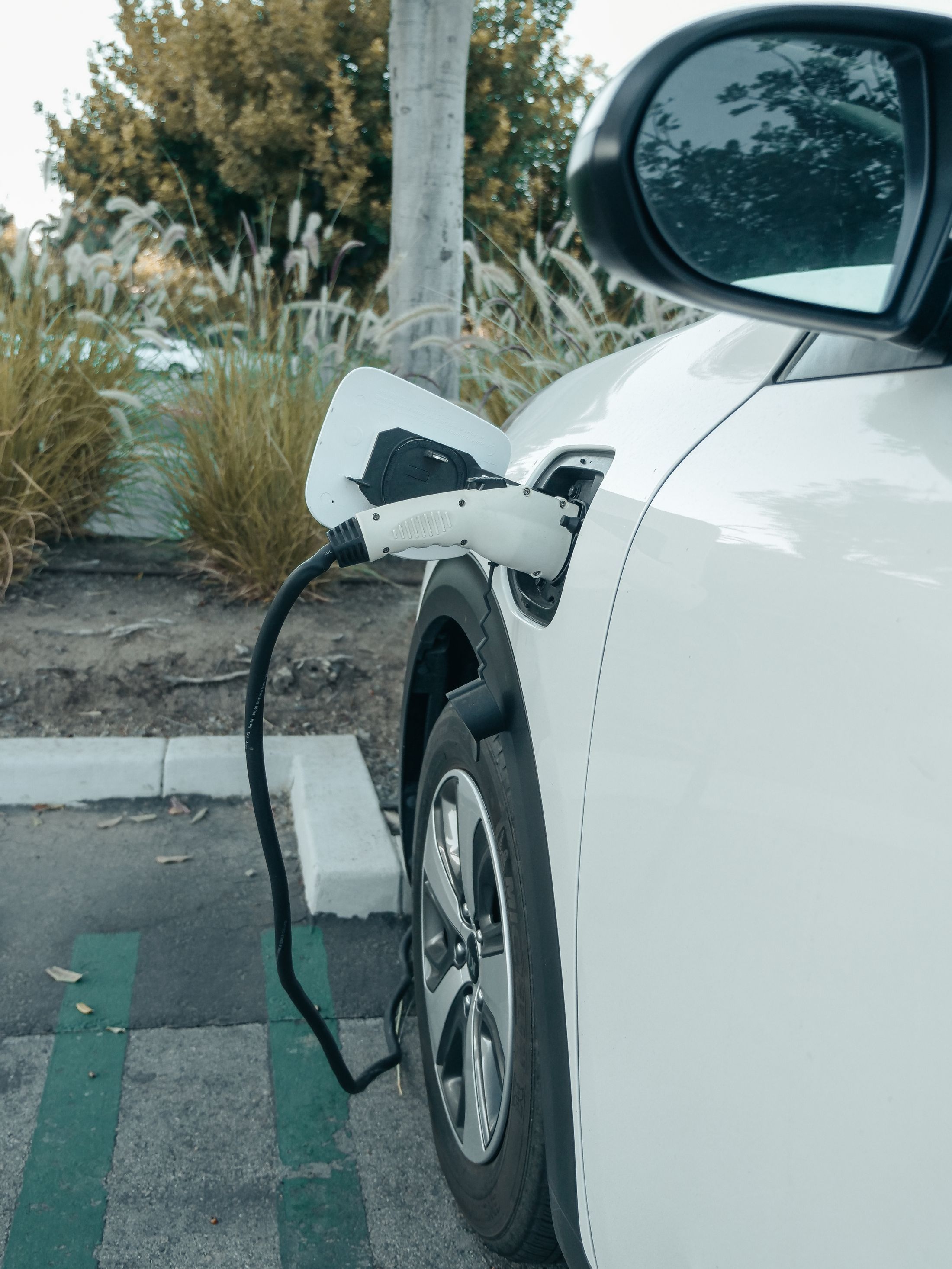 Prise de recharge branchée sur une voiture électrique blanche
